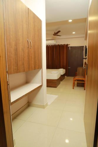 a bathroom with a sink and a toilet in a room at Plaza Tourist Home in Kannur