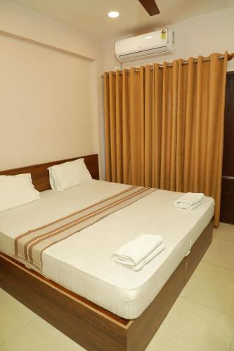 a bedroom with a bed with a window with a heater at Plaza Tourist Home in Kannur