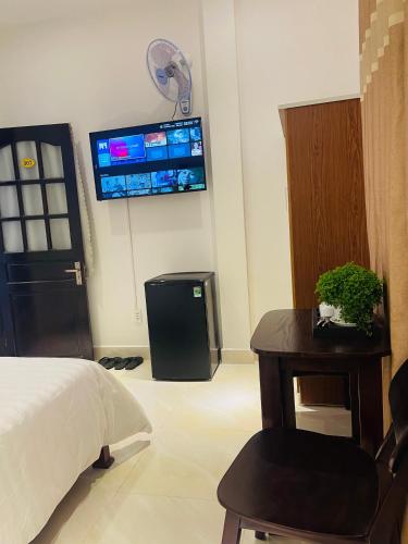 a bedroom with a bed and a tv on the wall at KHÁCH SẠN ROMO in Quang Ngai