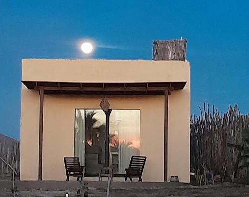 a small house with two chairs in front of it at Tres Velas Surf in Celestino Gasca
