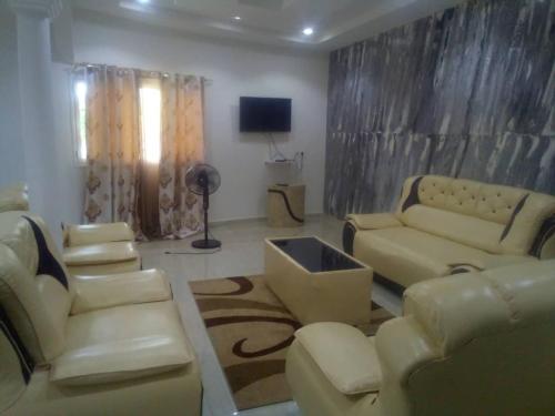 a living room with two couches and a television at keur fatou in Ngaparou