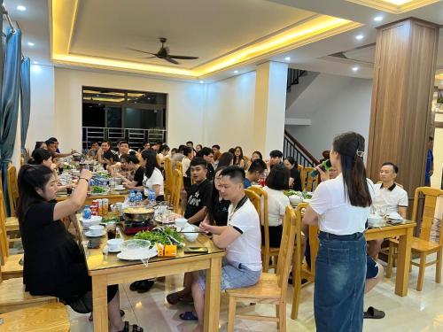 un grupo de personas sentadas en mesas comiendo comida en Blue Moon Tam Đảo en Sơn Ðình