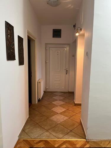 a hallway with a white door and a tile floor at City Apartment Gevgelija in Gevgelija