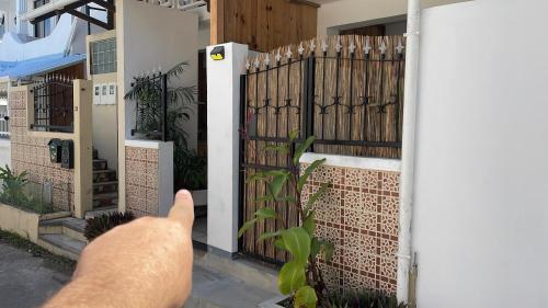 una persona apuntando a una puerta en una casa en Sam & Chlo Studio & Appartment - Grand Baie - Mauritius, en Grand Baie