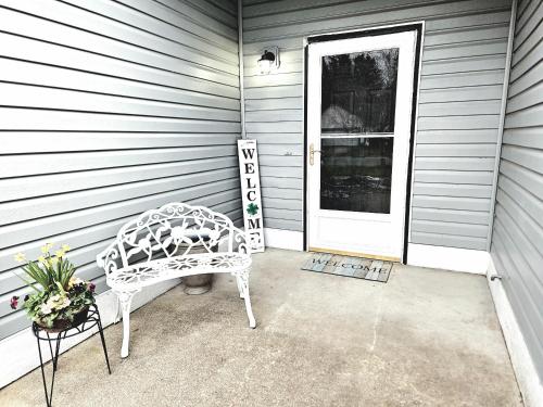 a white bench sitting in front of a door at Casa Spanaway, an exceptional stay! in Spanaway