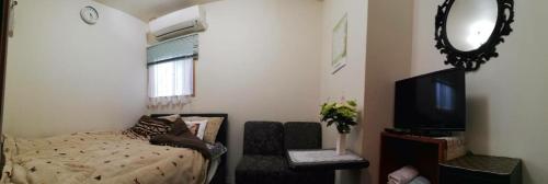 a bedroom with a bed and a mirror and a tv at Hanmadang in Osaka