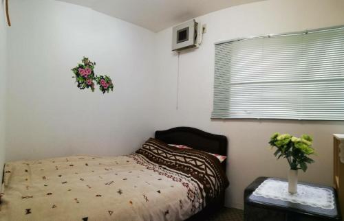 a bedroom with a bed and a wreath on the wall at Hanmadang in Osaka