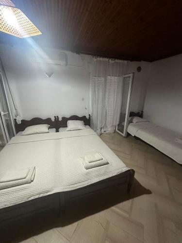 a bedroom with a large white bed in a room at Pansion Angela in Skiathos Town