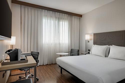 a hotel room with a bed and a desk and a television at AC Hotel Bologna by Marriott in Bologna