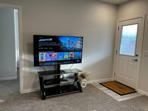 a flat screen tv sitting on a stand in a room at Brand New - Home Away from Home in NW Calgary in Calgary