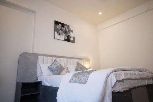 a bedroom with a bed with white sheets and pillows at DrizzleDrop Inn Chennai in Chennai