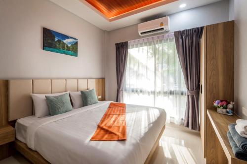 a bedroom with a large bed with a window at Mook Anda Villa in Ao Nang Beach