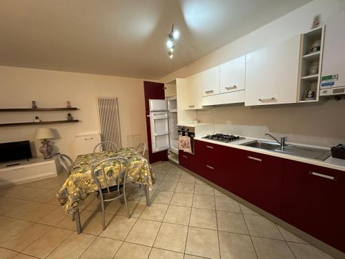 Val di Non Apartment في كليس: مطبخ مع طاولة وموقد فرن علوي