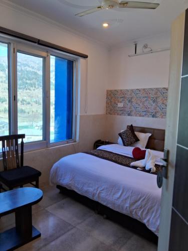 sypialnia z łóżkiem, stołem i oknem w obiekcie SR Hotel & Restaurant 2.0 w mieście Lohārakot