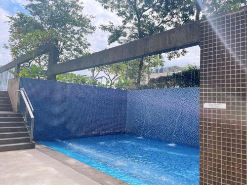 een zwembad met een blauwe tegelmuur en een trap bij USJ One Residence Cozy Homestay Subang Jaya Sunway USJ in Subang Jaya