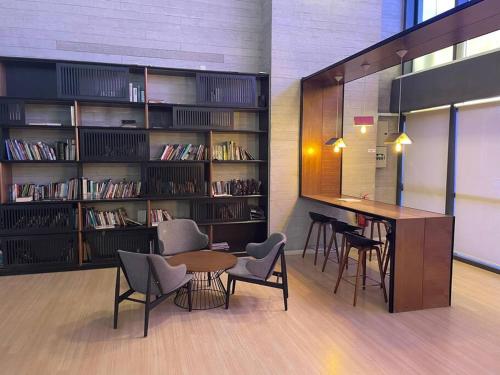 uma biblioteca com mesa, cadeiras e estantes em USJ One Residence Cozy Homestay Subang Jaya Sunway USJ em Subang Jaya