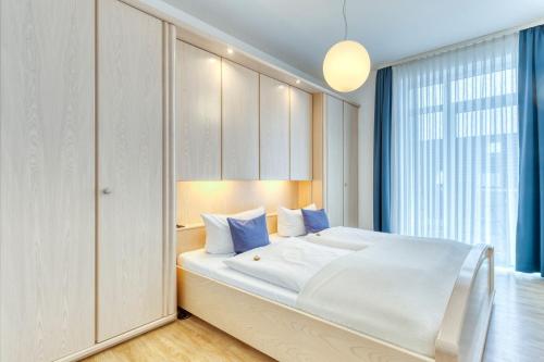 ein Schlafzimmer mit einem großen weißen Bett mit blauen Kissen in der Unterkunft Buten un Binnen in Norderney