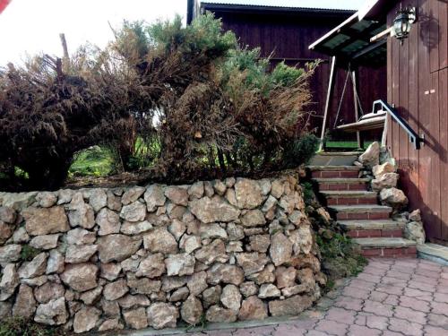 a stone retaining wall with a stone staircase next to a house at Moja Ostoja in Kluszkowce