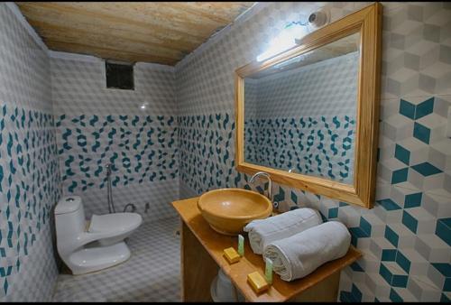 a bathroom with a sink and a toilet and a mirror at Club Desert Safari Jaisalmer in Sām