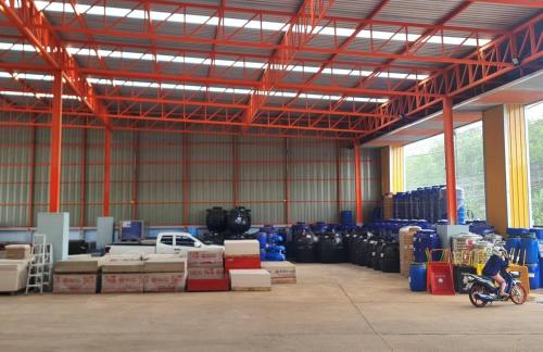 a warehouse with a room filled with boxes and a motorcycle at Starseed in Trang