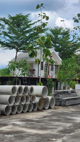 un tas de tuyaux assis devant une maison dans l'établissement Starseed, à Trang