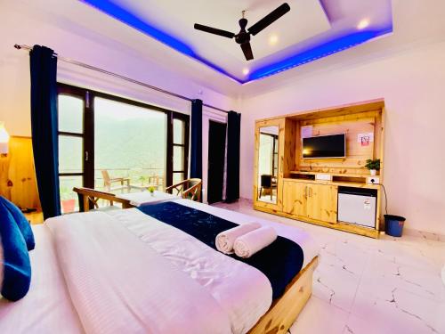 um quarto com uma cama grande e uma televisão em The Four Season Resort - Top Rated & Most Awarded Property in Mussoorie em Mussoorie