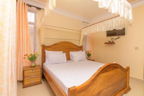 a bedroom with a wooden bed and a television at Dubai infinite luxury suites in Malindi