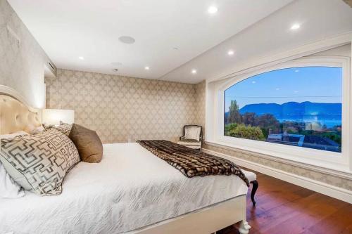 een slaapkamer met een bed en een groot raam bij Luxury 5-bedrooms in Vancouver Point Grey in Vancouver