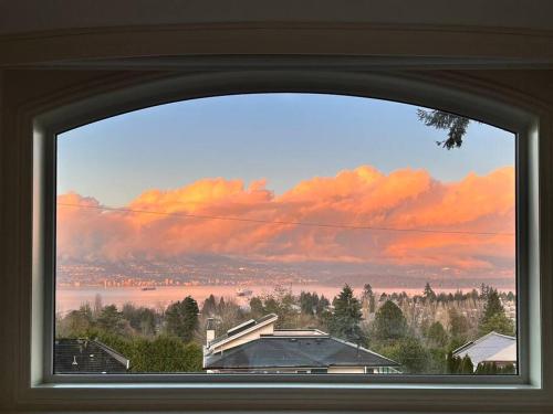 a window with a view of a city and clouds at Luxury 5-bedrooms in Vancouver Point Grey in Vancouver
