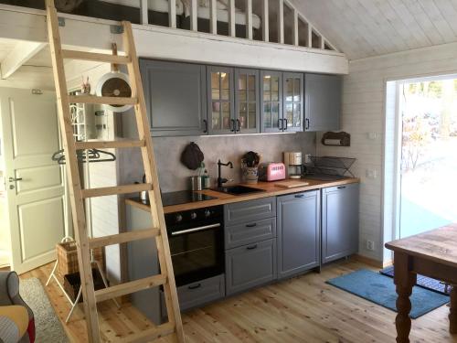 una cocina con armarios grises y una escalera en Pippis Cottage en Tingsryd