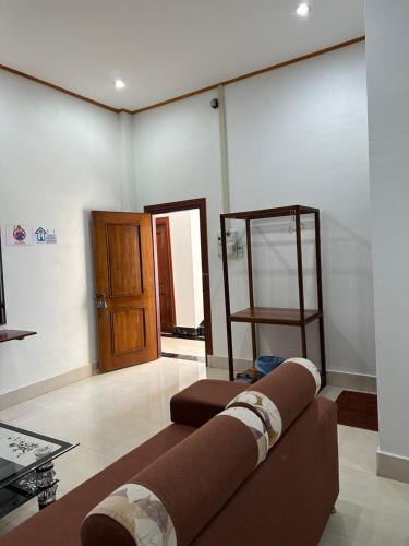 a living room with a couch and a wooden door at narixay hotel in Phonsavan