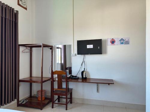 a room with a desk and a television on a wall at narixay hotel in Phonsavan