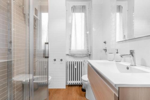 bagno bianco con servizi igienici e lavandino di [Free park- San Siro - Mediolanum Forum 15 min] a Milano