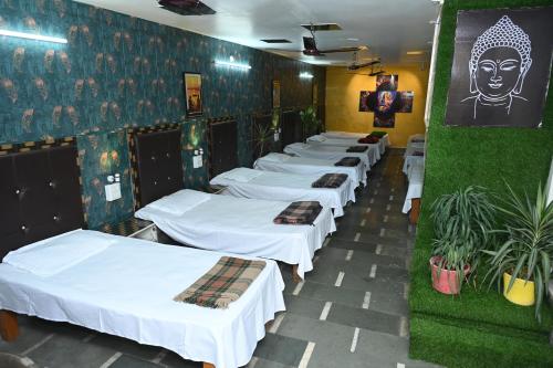 uma fila de camas estão alinhadas num quarto em Siddhivinayak Temple Guest House em Varanasi