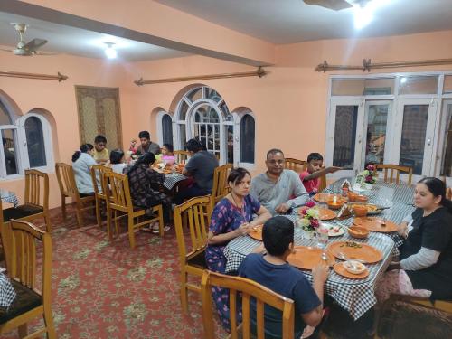 a group of people sitting at tables in a restaurant at Hotel Bakhtawar in Srinagar