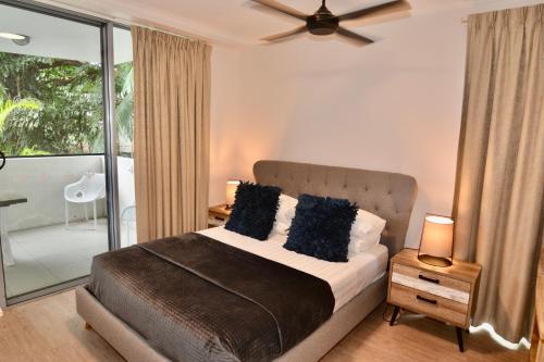 a bedroom with a bed and a balcony at Tropical Luxe Apartment in Townsville