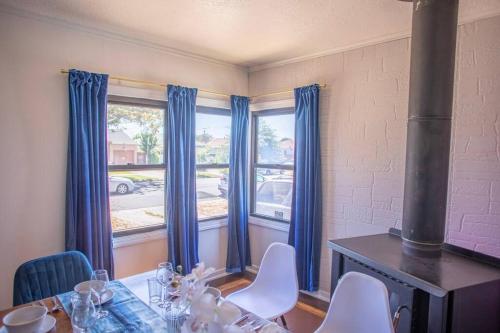 a dining room with blue curtains and a table and chairs at PlanetView Delux Richmond XL- walk Best MexFood in Richmond