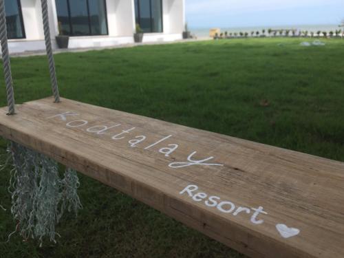 a wooden sign that readsnatural resort and a house at Kodtalay Resort in Chao Lao Beach