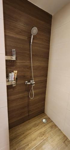 eine Dusche in einem Zimmer mit einer Holzwand in der Unterkunft Nagoya Thamrin City Apartment High Floor in Nagoya