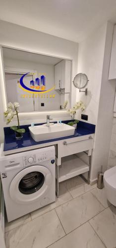 a bathroom with a washing machine and a sink at INTERSTELLAR ☆ ORBI CITY in Batumi