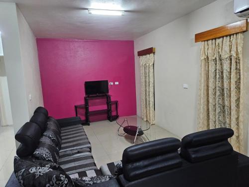 sala de estar con sofá y TV en Bula Stay, en Nadi