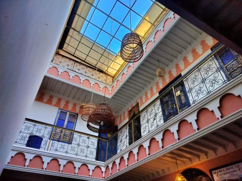 um edifício com um tecto de vidro com lustres em RIAD MAMAHOUSE em Marrakech