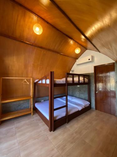 two bunk beds in a room with wooden walls at East Holiday Resort Moalboal in Moalboal