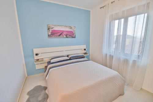 een kleine slaapkamer met een bed in een kamer met een raam bij Moderno alloggio in zona pedonale in Chivasso