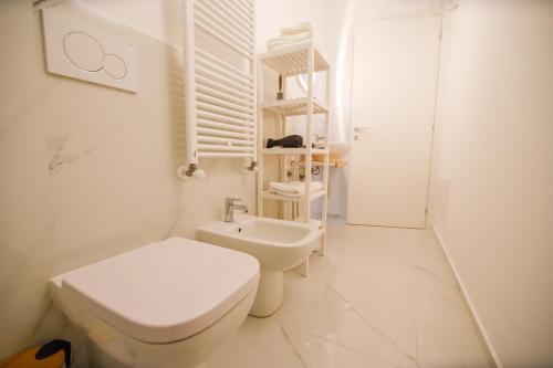 a white bathroom with a toilet and a sink at Moderno alloggio in zona pedonale in Chivasso