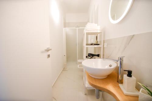een badkamer met een witte wastafel op een houten aanrecht bij Moderno alloggio in zona pedonale in Chivasso