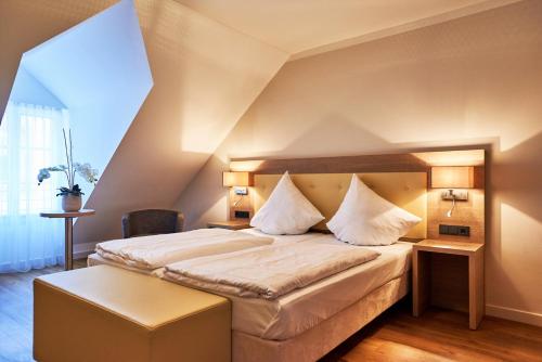 een slaapkamer met een groot bed met witte lakens bij Hotel Doctor Weinstube in Bernkastel-Kues