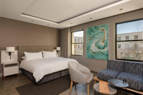 1 dormitorio con 1 cama y 1 sofá en Protea Hotel by Marriott Cape Town Waterfront Breakwater Lodge, en Ciudad del Cabo