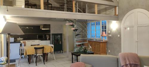 eine Küche und ein Esszimmer mit einem Loft in der Unterkunft La Petite Maison in Givry