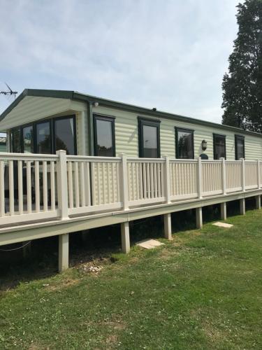 a mobile home with a white fence at Lazeeedays on Mersea Island in Colchester